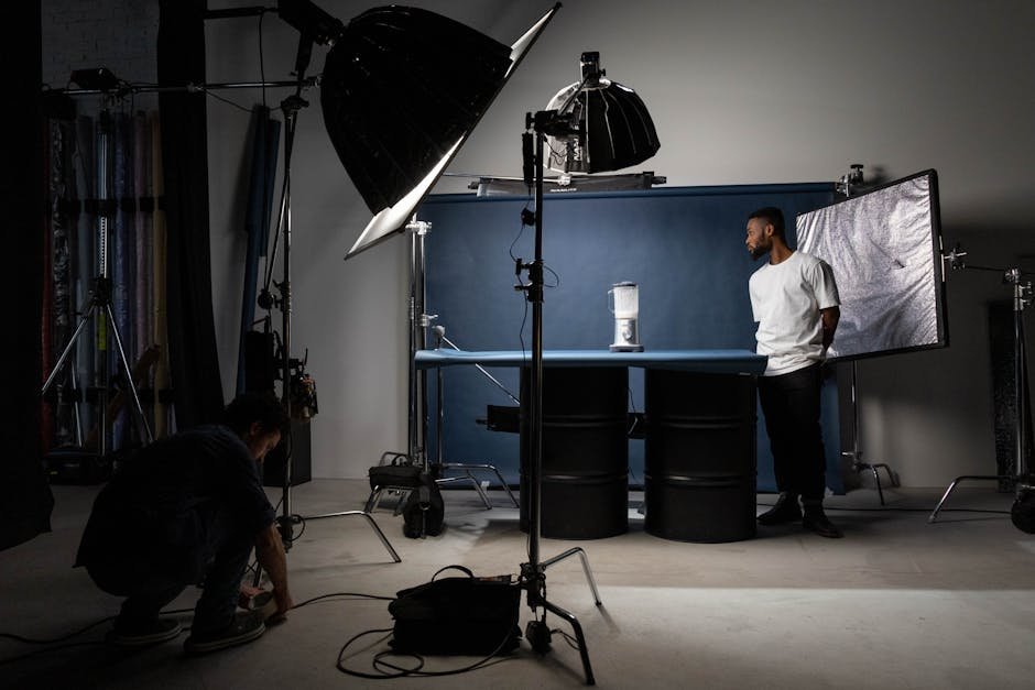 Studio setup showing lighting equipment, a model, and crew during a photo shoot.