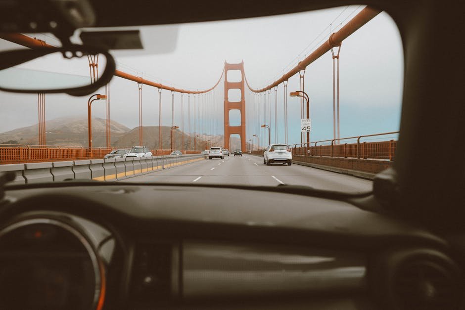 Driving over the iconic Golden Gate Bridge with a view through the car windshield, capturing the bustling road.