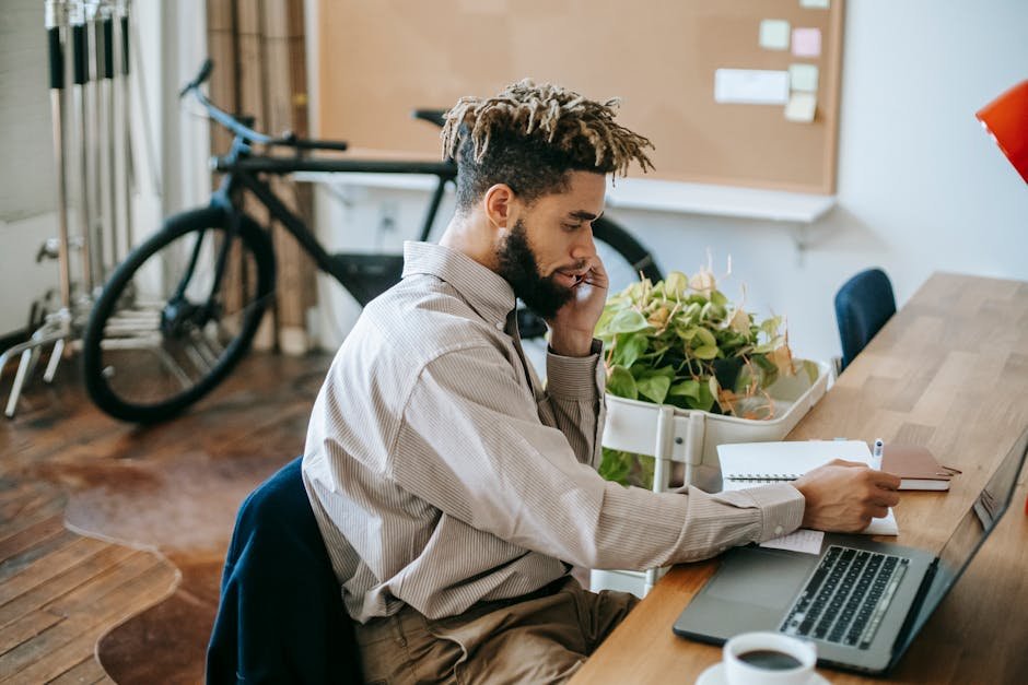 A young male freelancer working on a laptop in a stylish office