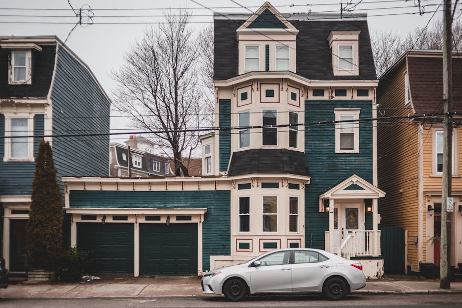 Exterior of aged colorful houses with attics and small windows with car parked on pavement